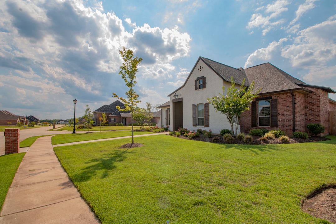 white-and-brown-house-near-green-grass-field-under-white-clouds-and-blue-sky-during-daytime-9ggvnwbeoq4
